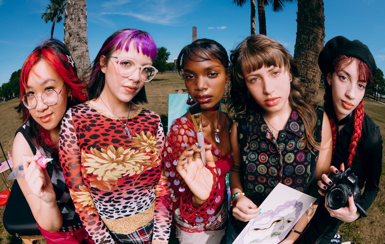 A diverse group of teen artists showcasing their creativity and unique styles in an outdoor setting.
